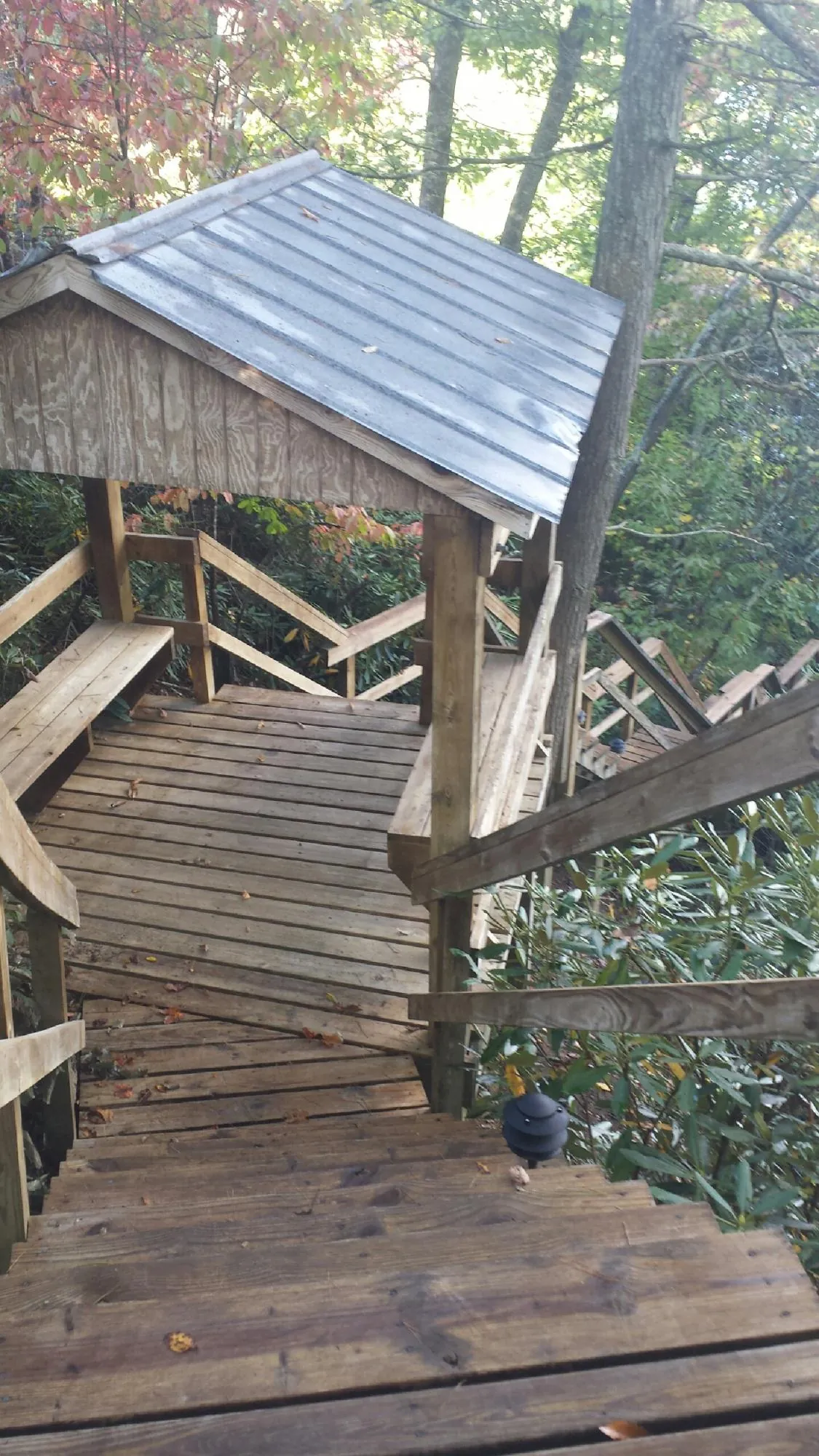 Metal roofed shelter over wooden steps on a wooded walkway — Skylight Repair & Installation work by our crew in New Brunswick