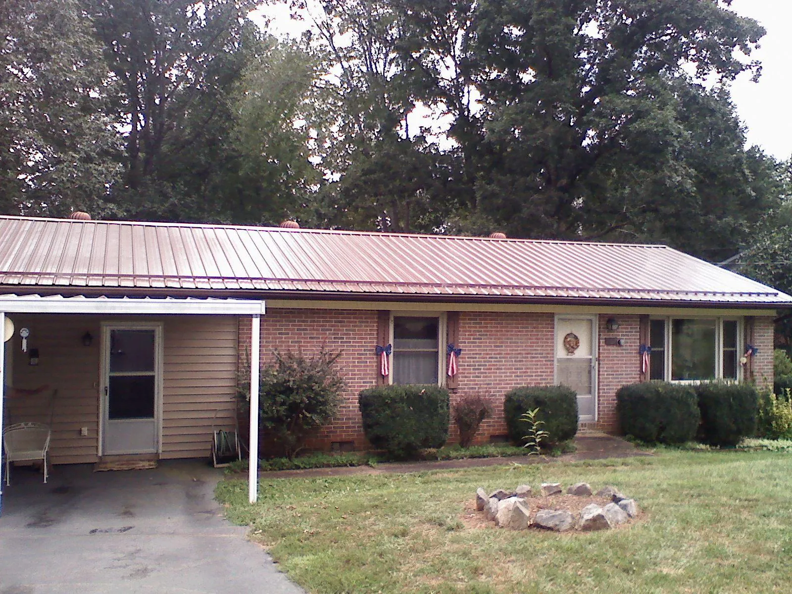 Bronze metal roof and carport on a brick ranch home — Roof Repair work by our crew in New Brunswick